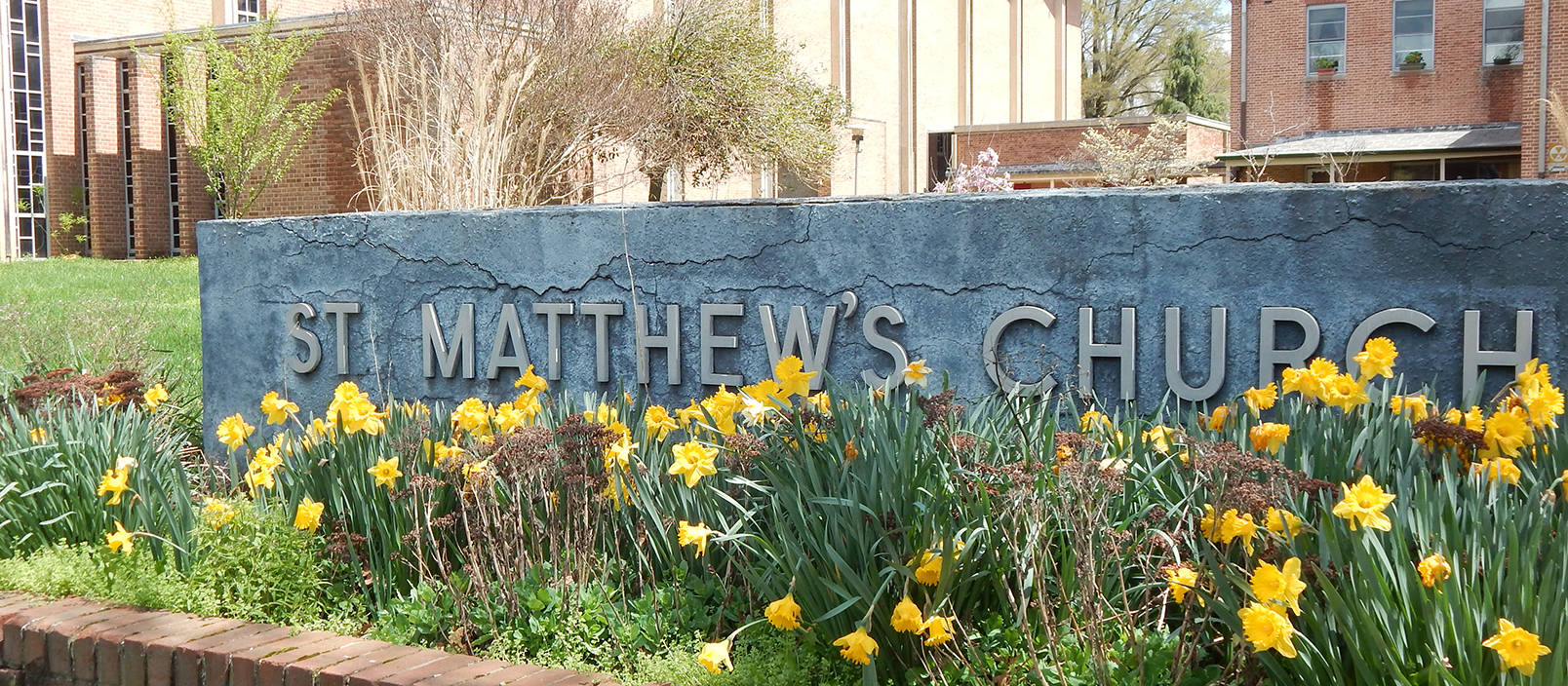 a sign that says st mathew's church surrounded by flowers
