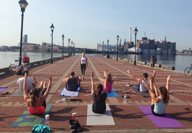 a group of people are doing yoga on the sidewalk