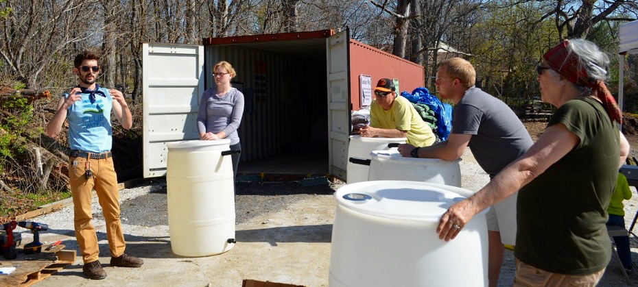 a group of people standing around a white container
