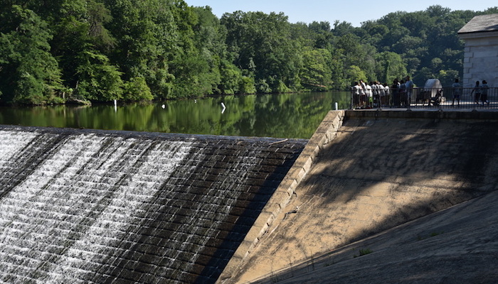people are standing at the top of a dam