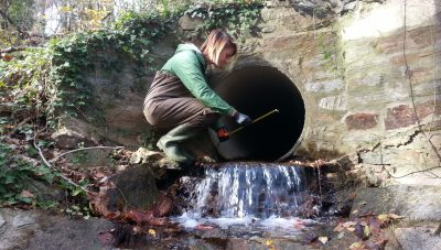 a woman is working on a water source