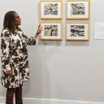 a woman looking at pictures on the wall