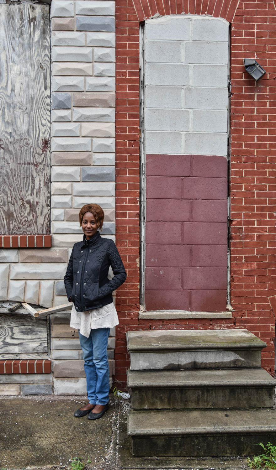 a woman standing in front of a brick building