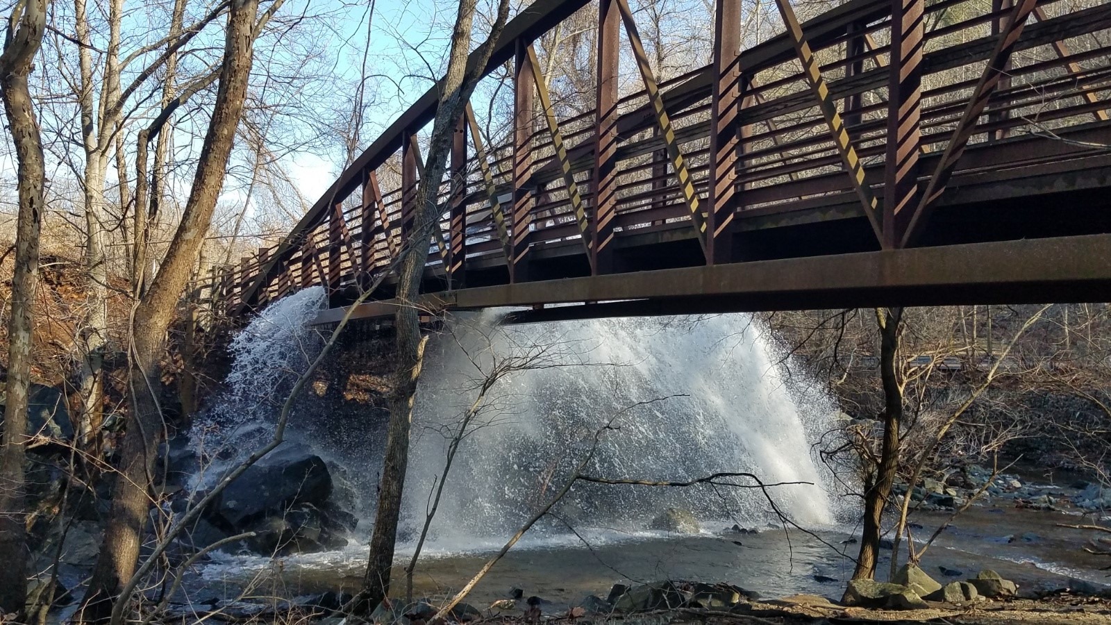 a wooden bridge over a small waterfall