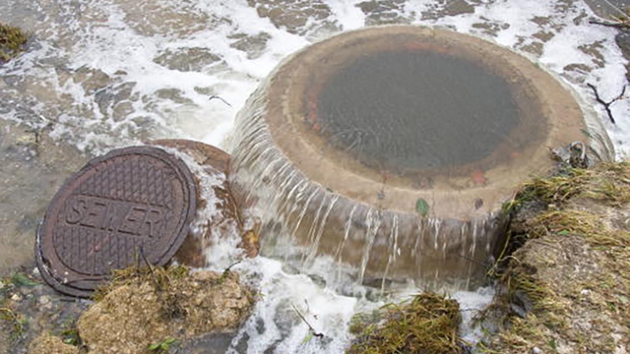 a manhole hole with water coming out of it