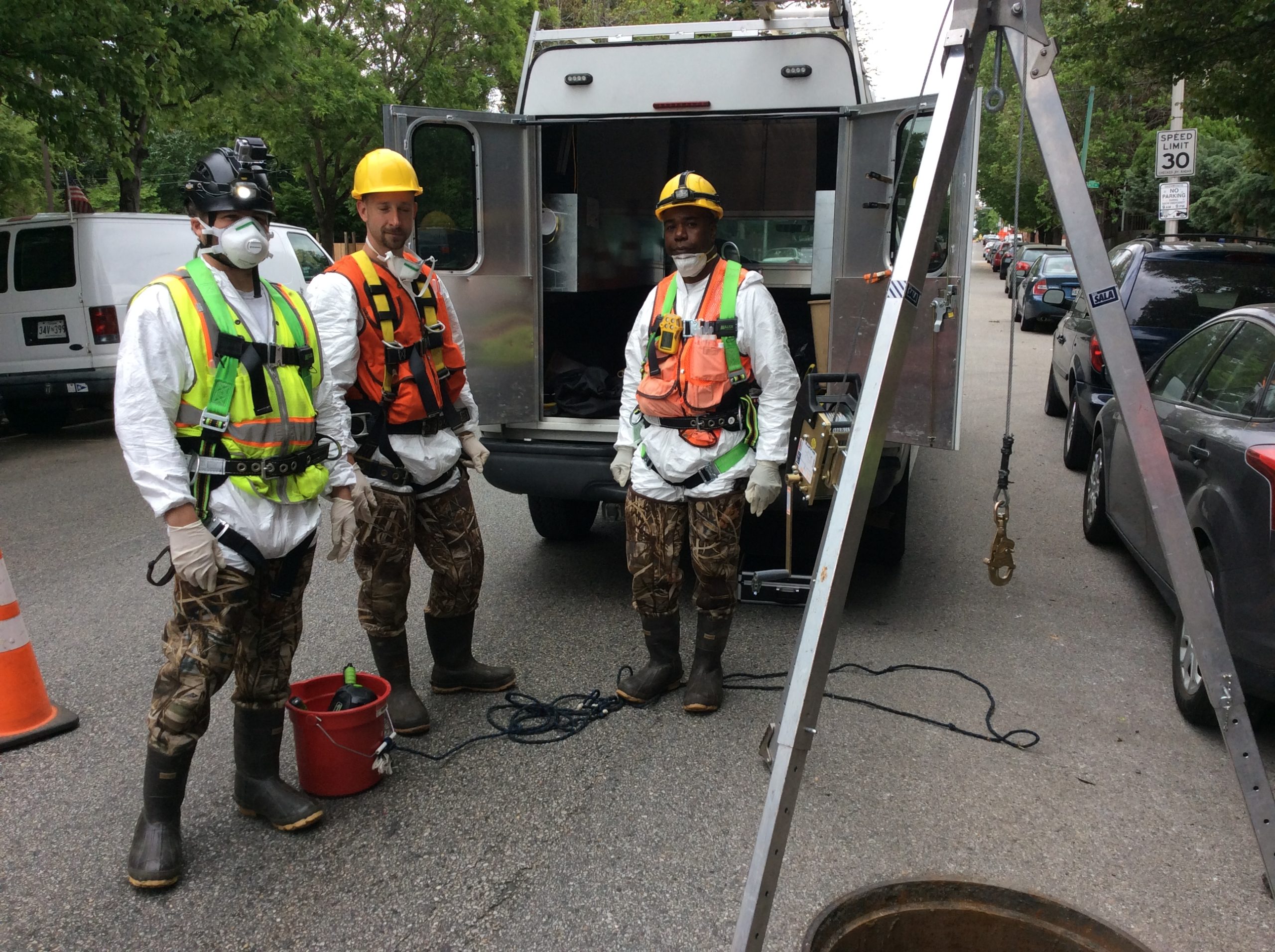 two men in safety gear standing next to a truck
