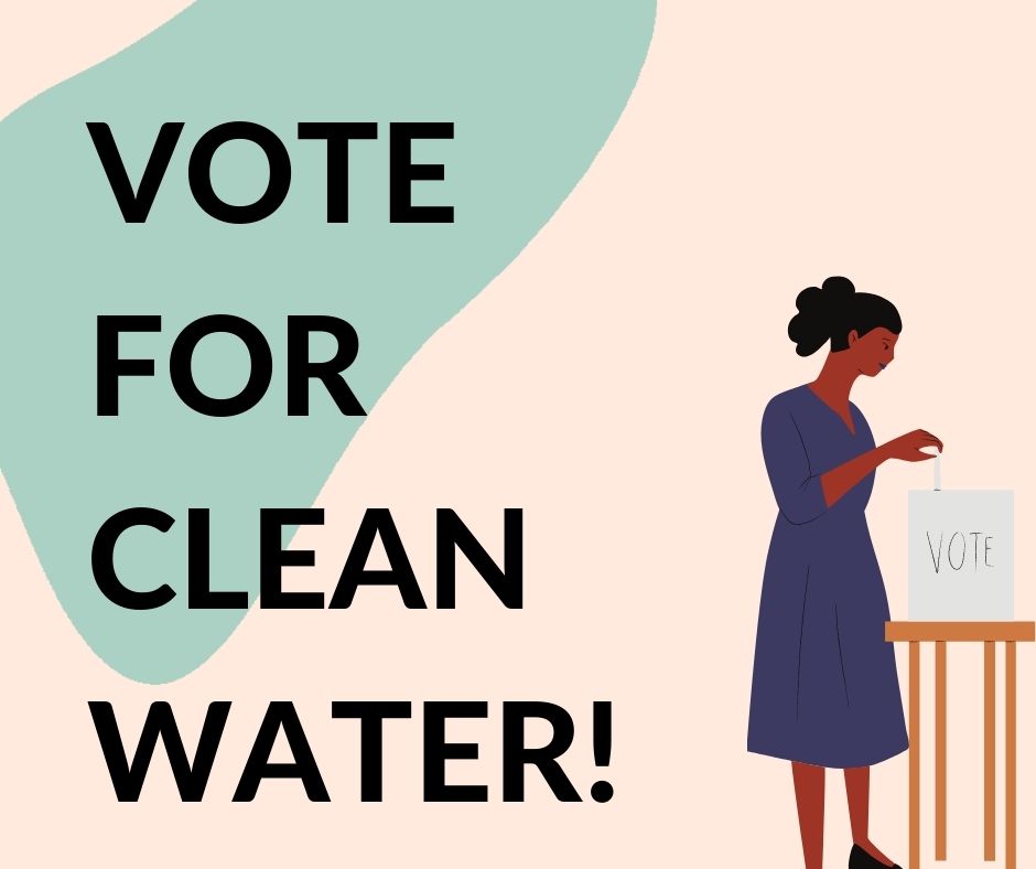 a woman standing in front of a table with a sign that says vote for clean water