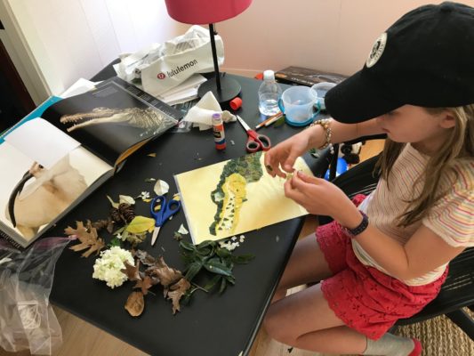 A young girl working on a nature collage
