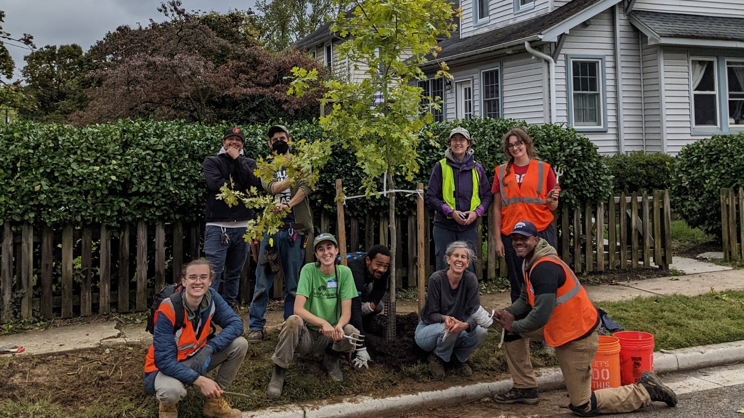 Volunteers and staff standing around a just-planted tree