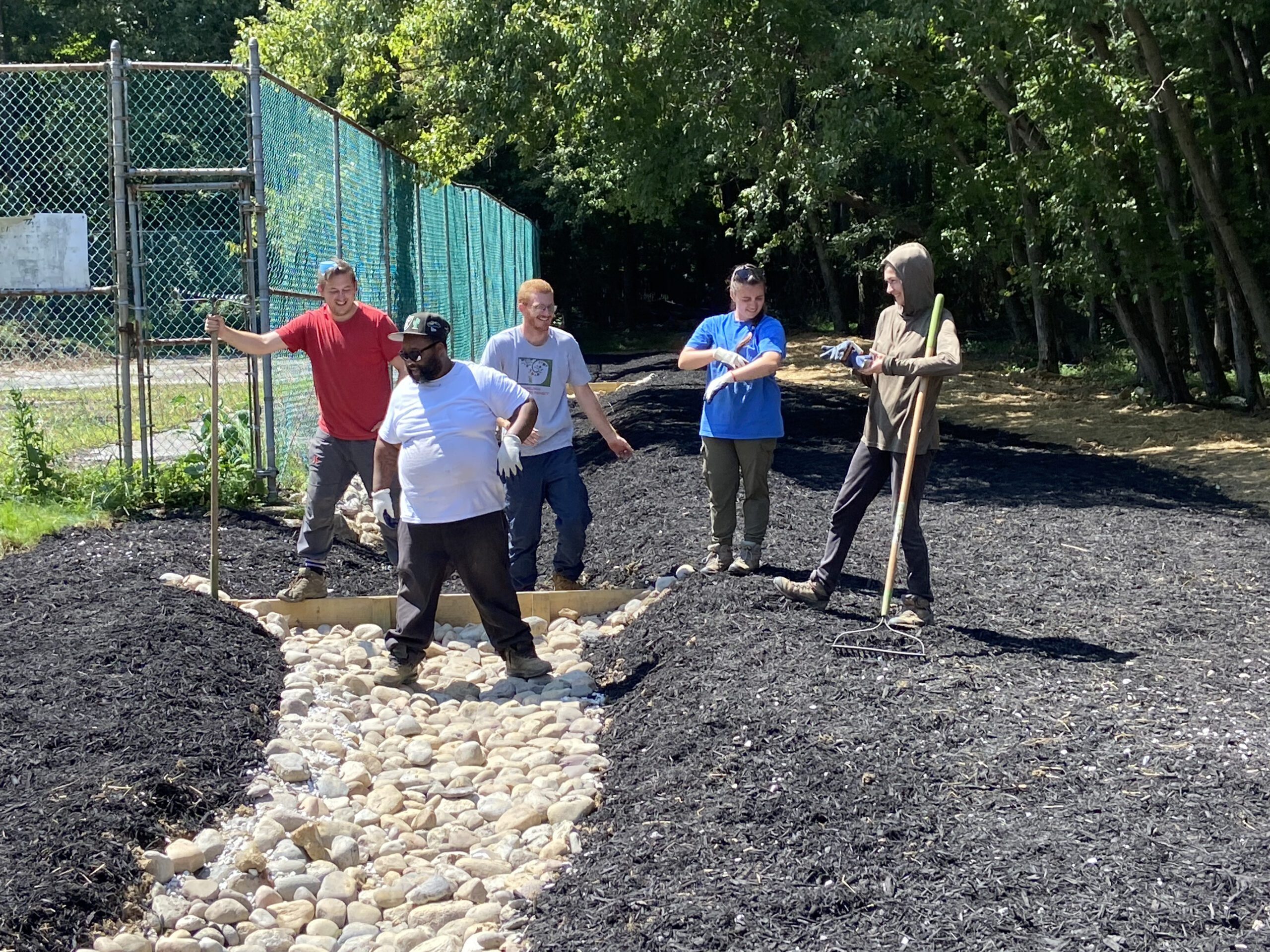 a group of people standing around a pile of mulch