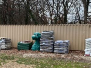 stacks of sand bags and containers in front of a fence