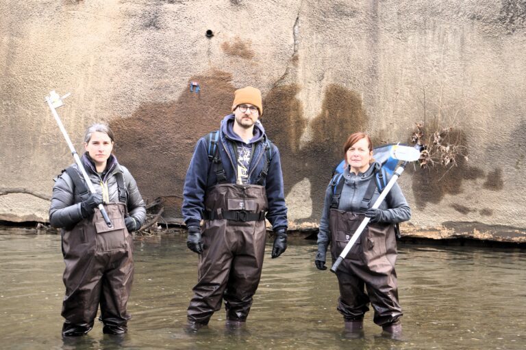 three people in waders standing in the water