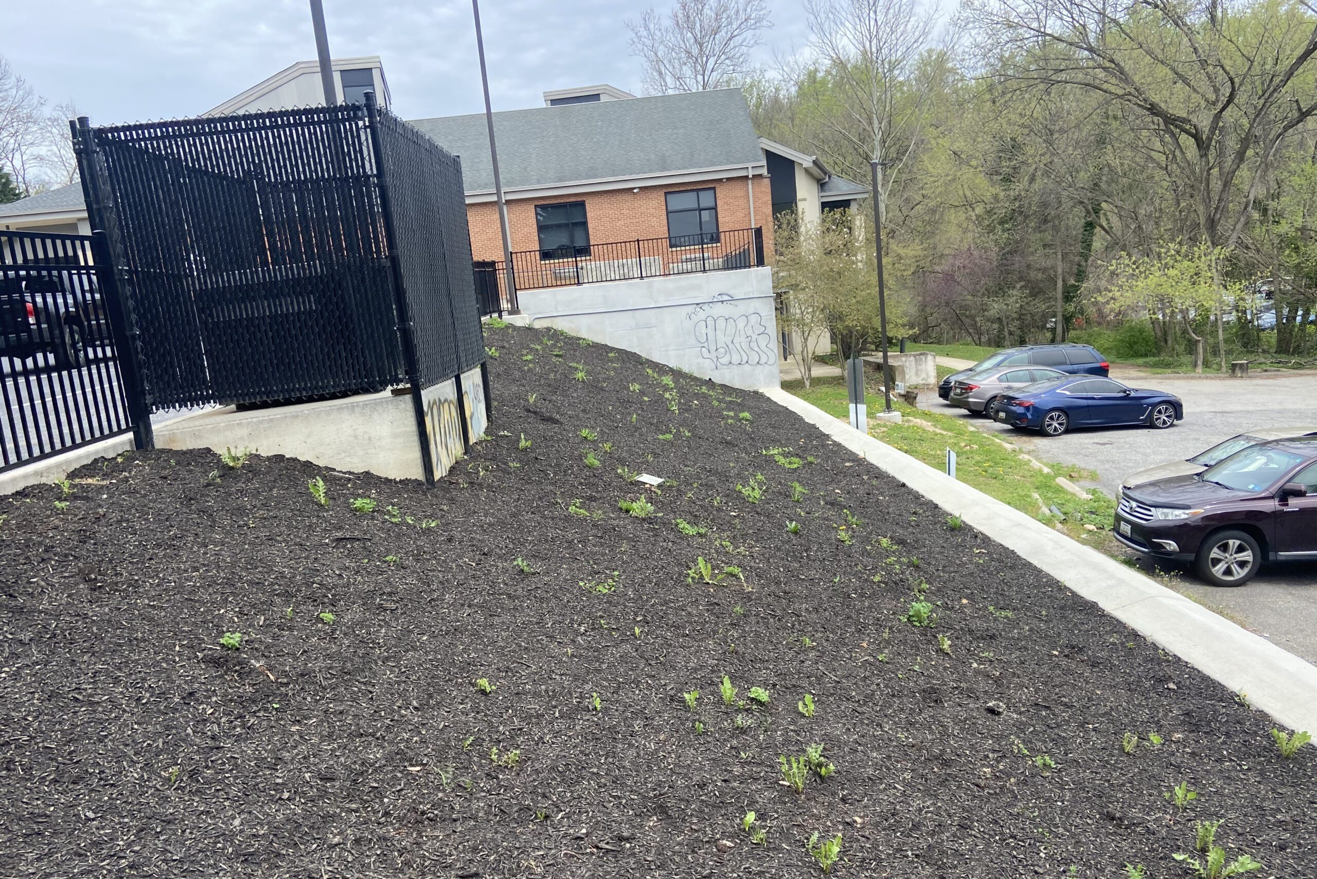 a car parked in front of a building next to a pile of dirt