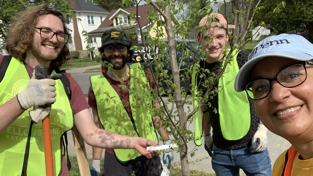 a group of people standing next to a tree