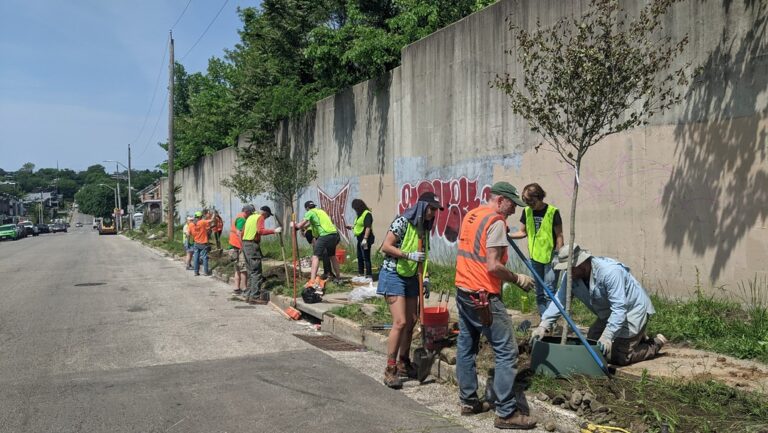 a group of men standing on the side of a road