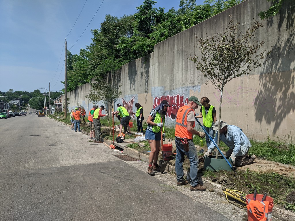 a group of men standing on the side of a road