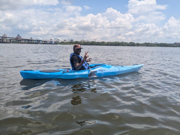 a man sitting in a blue kayak on the water