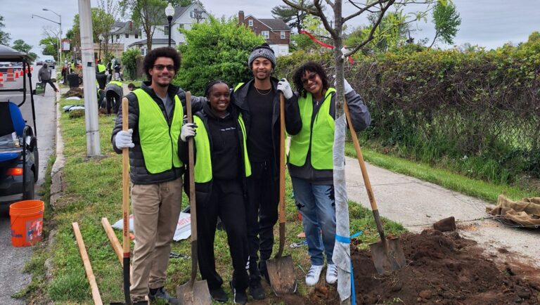 a group of people standing next to a tree