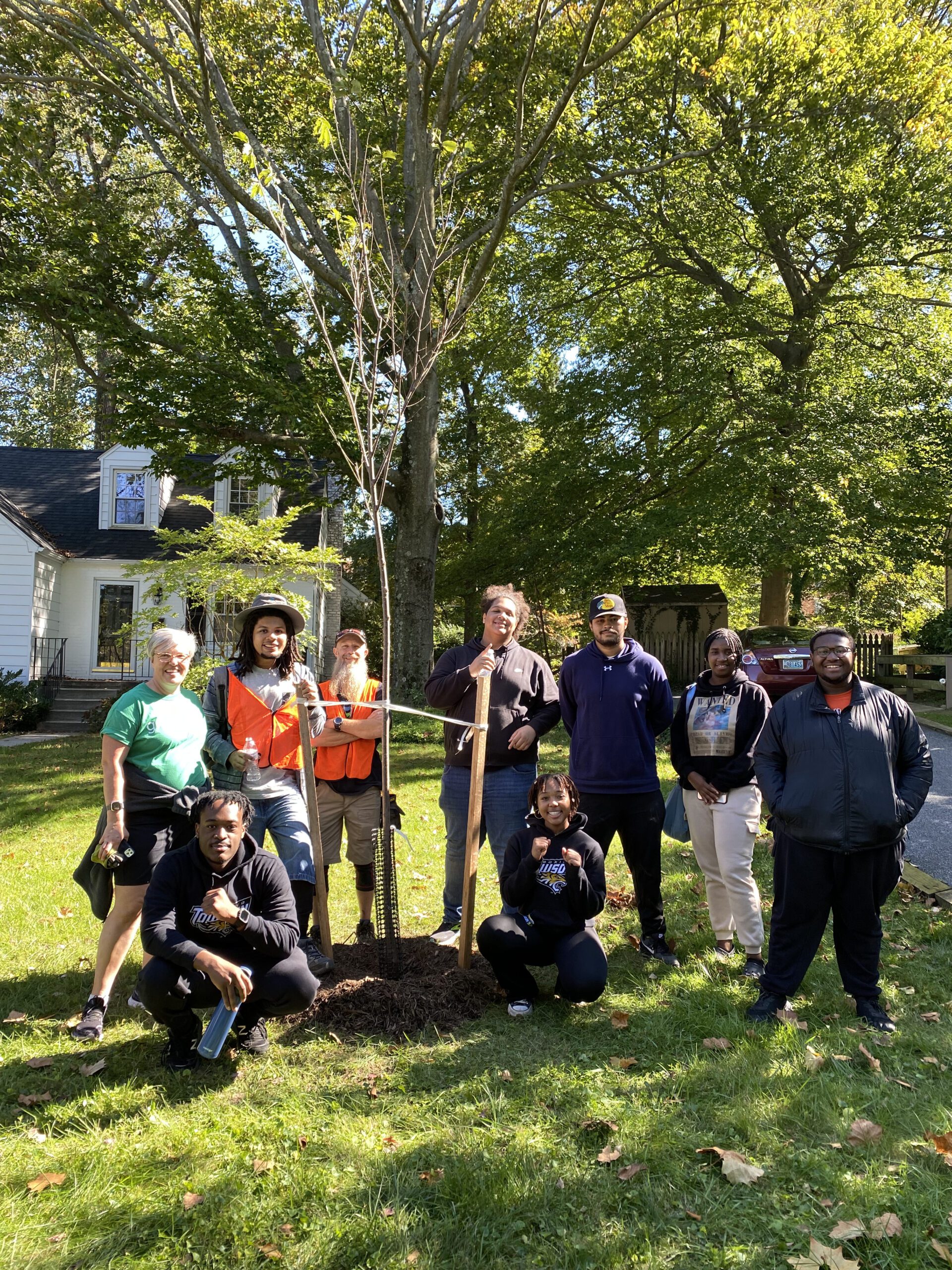 a group of people standing around a tree