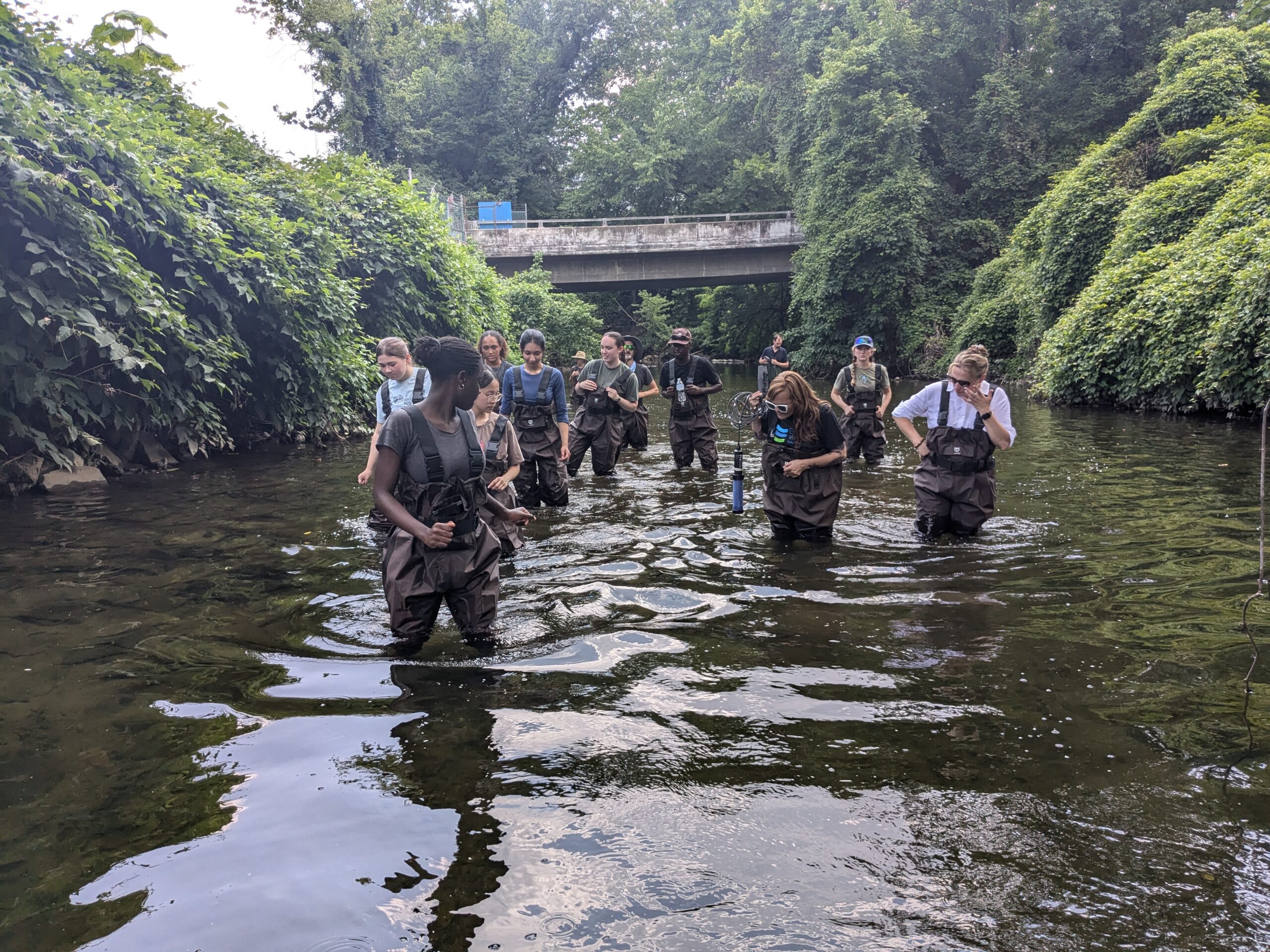 a group of people walking across a river